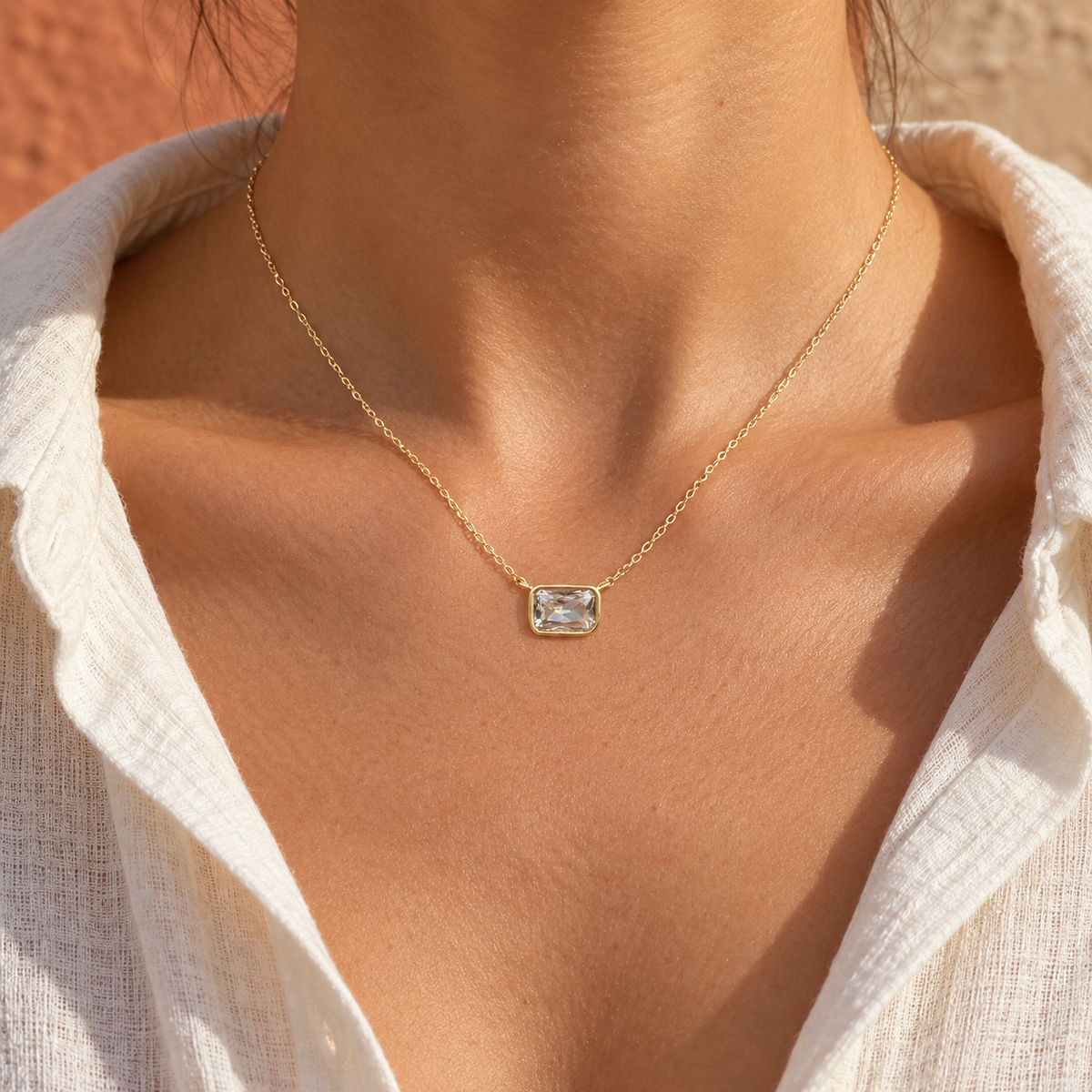 Brisa horizontal clear CZ necklace worn with ivory linen — digitally styled illustration; fit varies