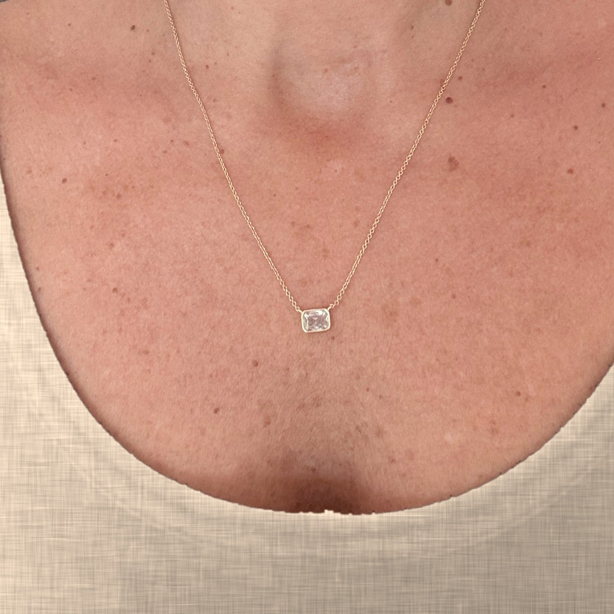 Brisa Clear CZ Necklace worn, cream linen