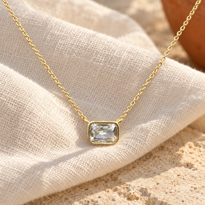 Brisa clear CZ necklace on warm ivory linen — digitally styled product image