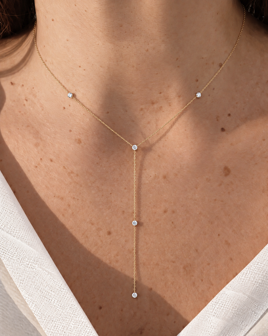 Chuva five-diamond lariat on a model in ivory linen; digitally styled.