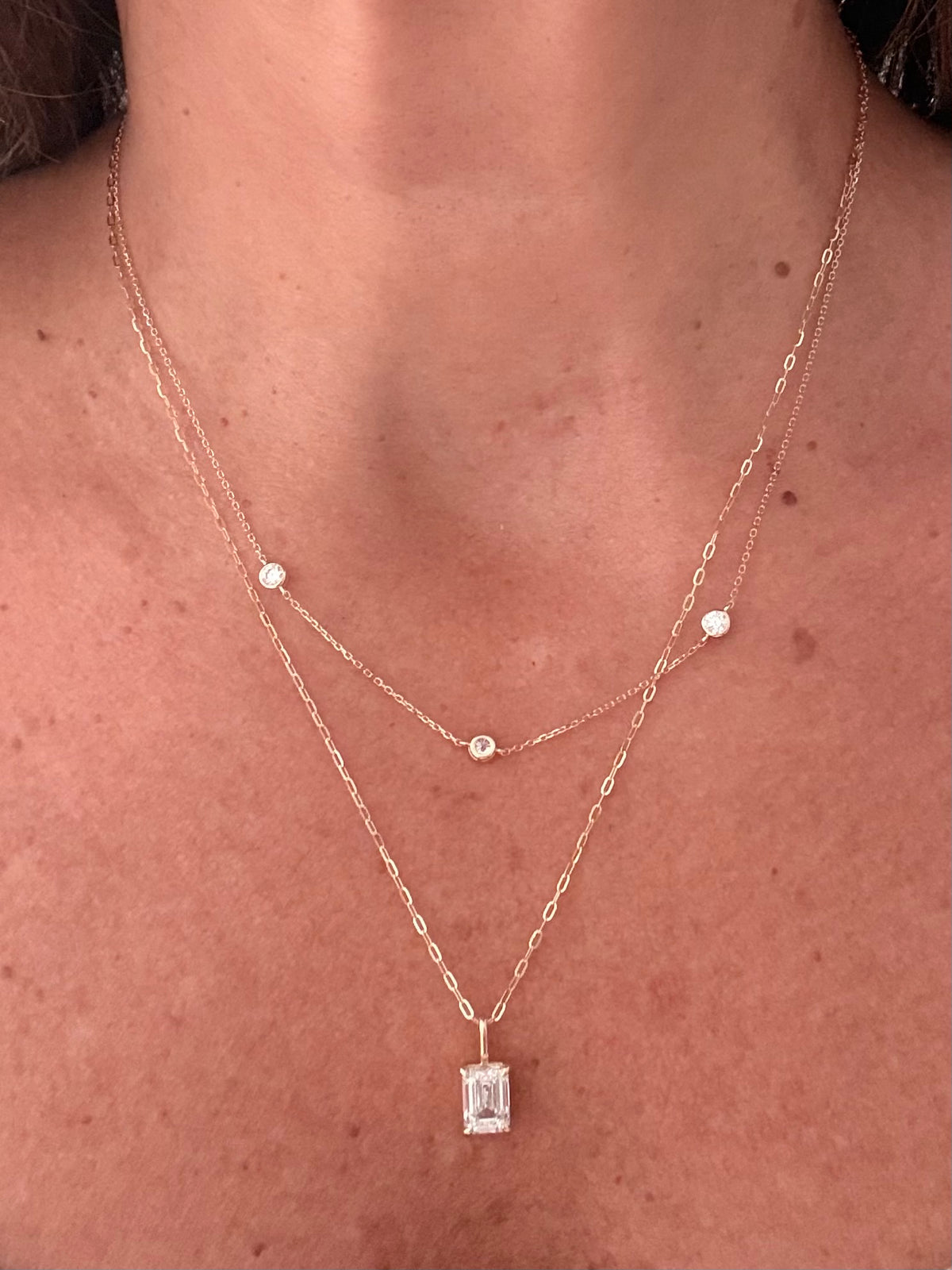 Clara emerald-cut diamond pendant layered on model with Pontos de Luz necklace; necklaces sold separately