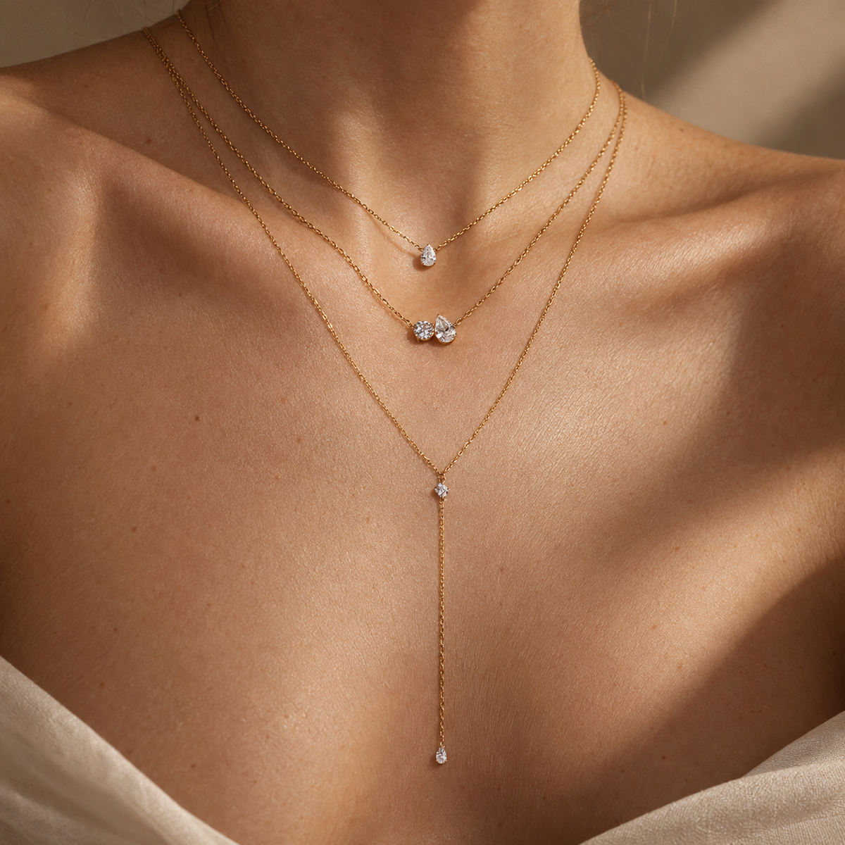 L’OURO-inspired editorial styling of three layered gold diamond necklaces; Encontro pear and round necklace in the middle