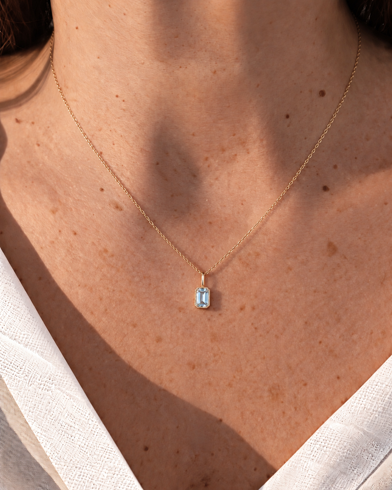 Helen aquamarine necklace on a model in ivory linen; digitally styled.