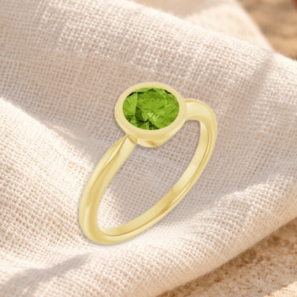 Verde peridot bezel ring on cream linen